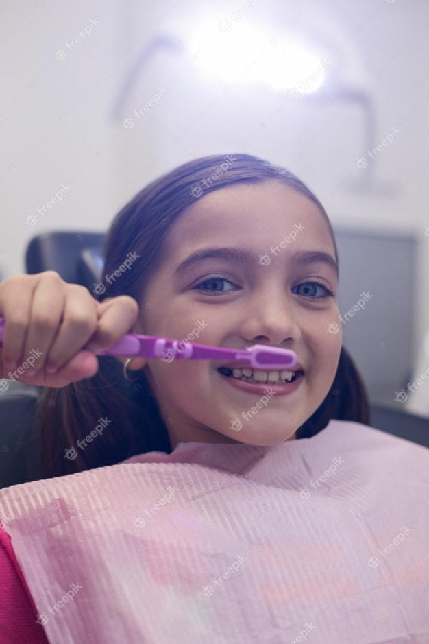 Paciente joven que se cepilla los dientes Foto Premium 